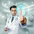 Professional doctor wearing lab coat and stethoscope while looking at hologram of human organ. Skilled researcher looking and thinking about medical theory. Innovation. Blurring background. Deviation.